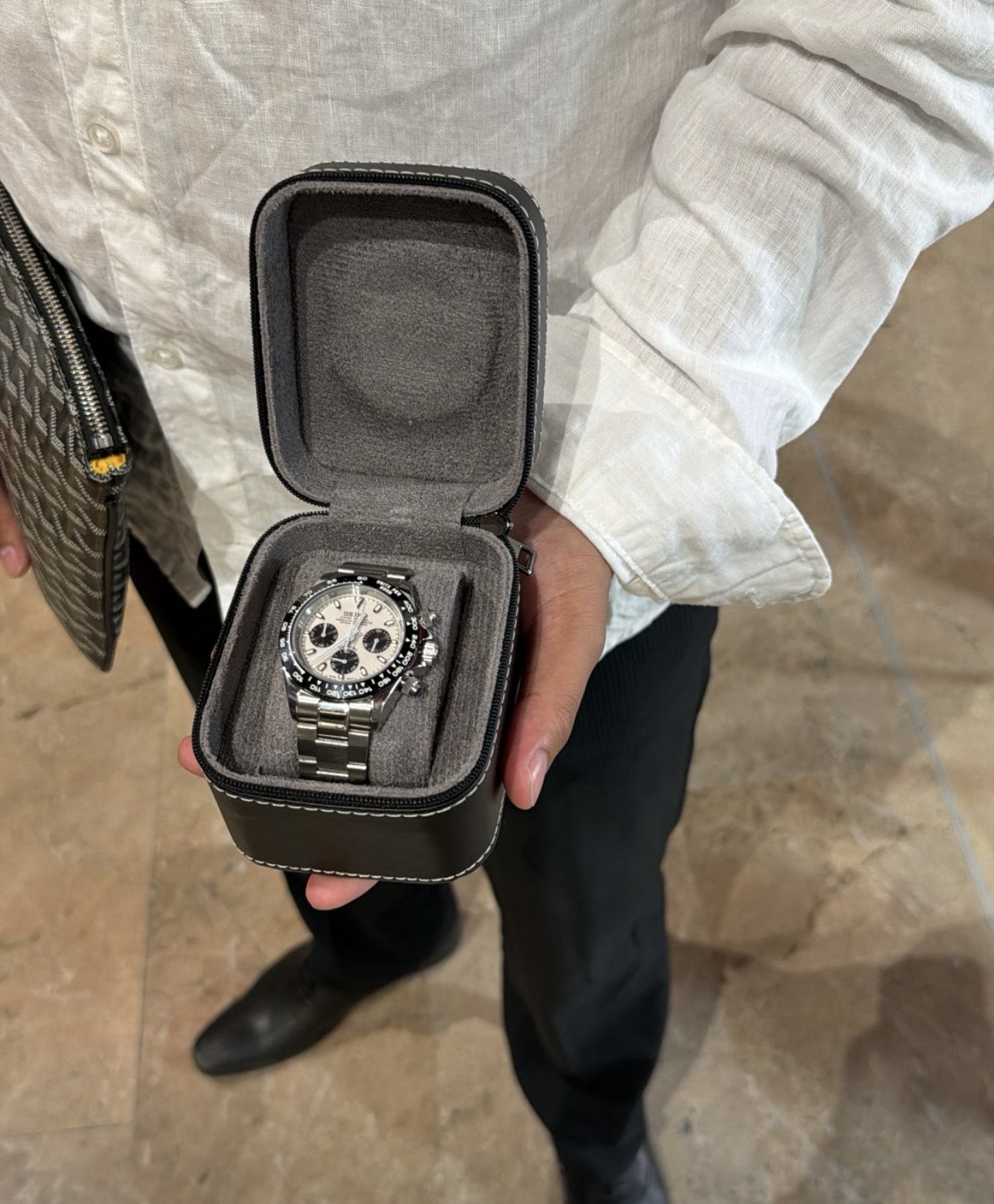 Client tenant son coffret avec la montre chronographe acier