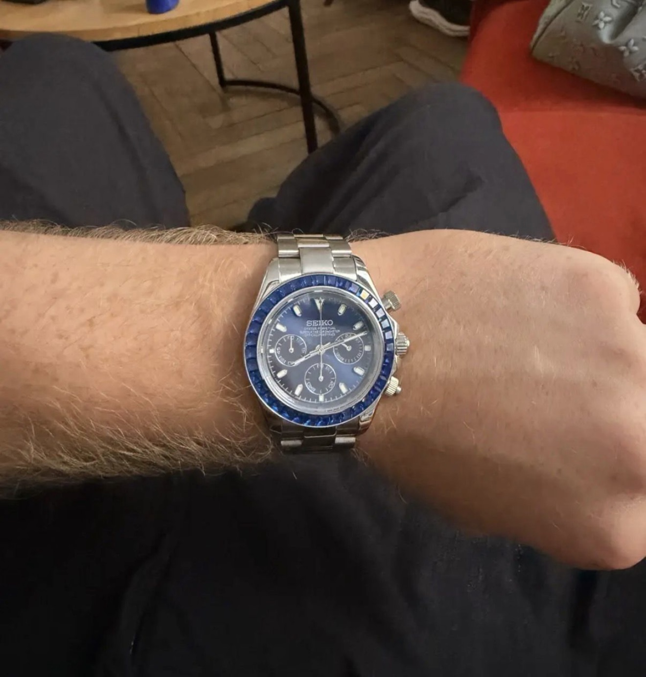 Client portant un chronographe acier cadran bleu serti