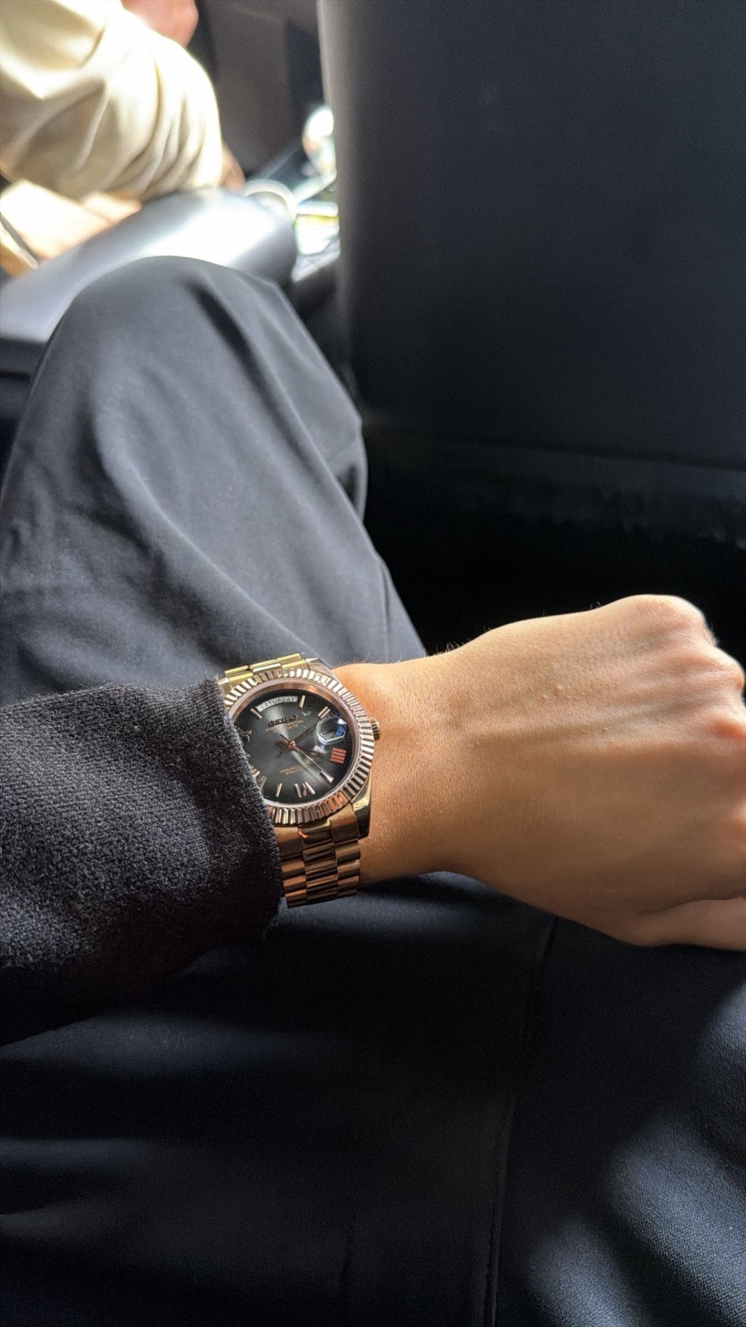 Client portant une montre or rose cadran foncé