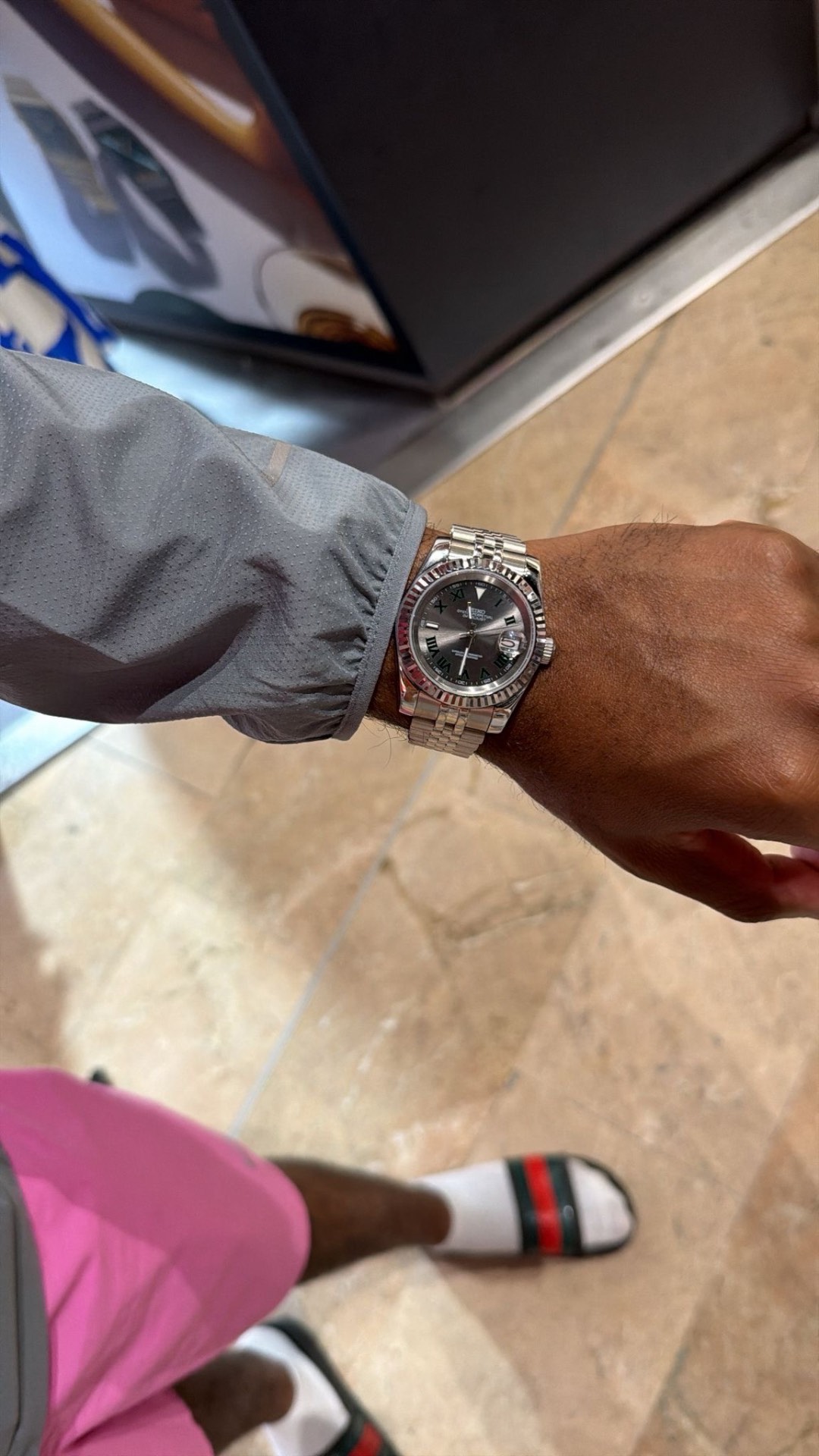 Client portant une montre acier cadran gris